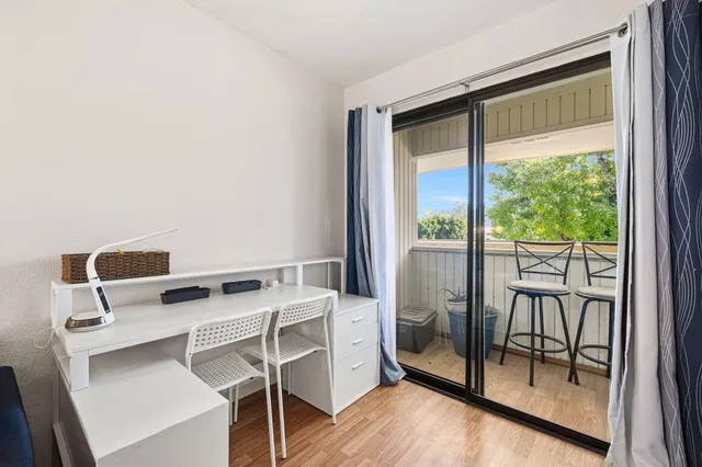 a view of a workspace with furniture and a window