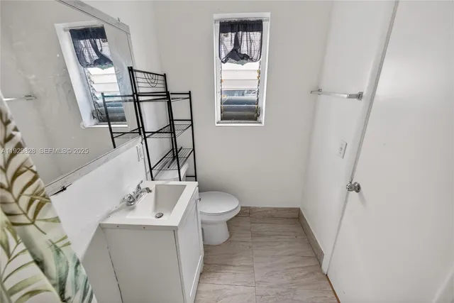 a bathroom with a sink toilet and a mirror