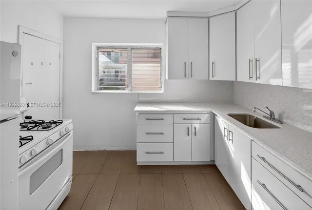 a kitchen with white cabinets and white appliances