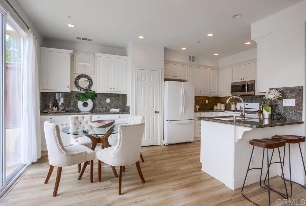 518 Beach Street Encinitas, CA 92024 - Photo 15 of 43 a kitchen with stainless steel appliances granite countertop a table chairs a refrigerator a stove a microwave a dining table and chairs