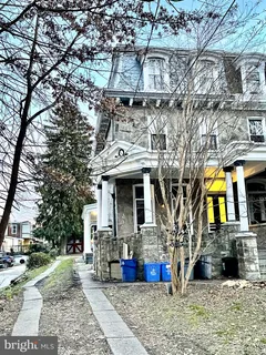 a view of a white house with large windows and a small yard