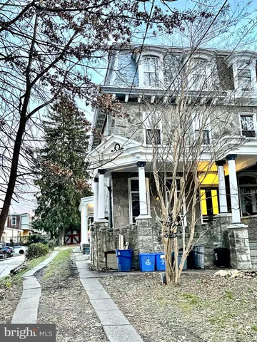 a view of a white house with large windows and a small yard