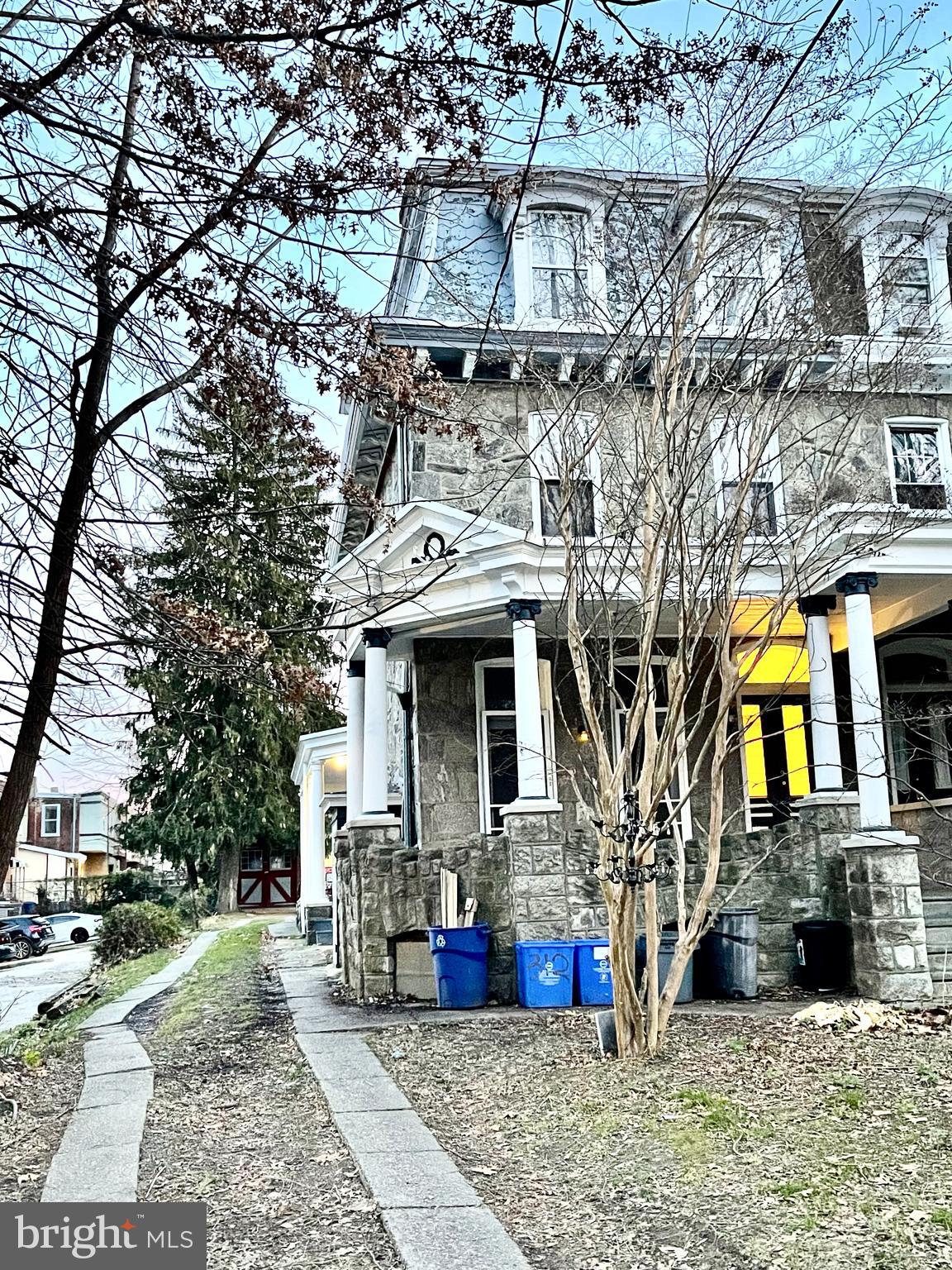 a view of a white house with large windows and a small yard