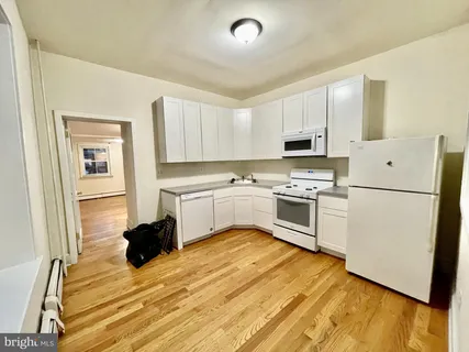 a room with a bed and a view of kitchen