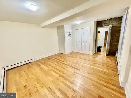 a view of a room with wooden floor and white walls
