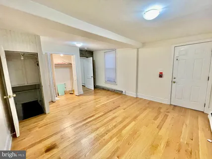 a view of a bedroom with wooden floor and bathroom