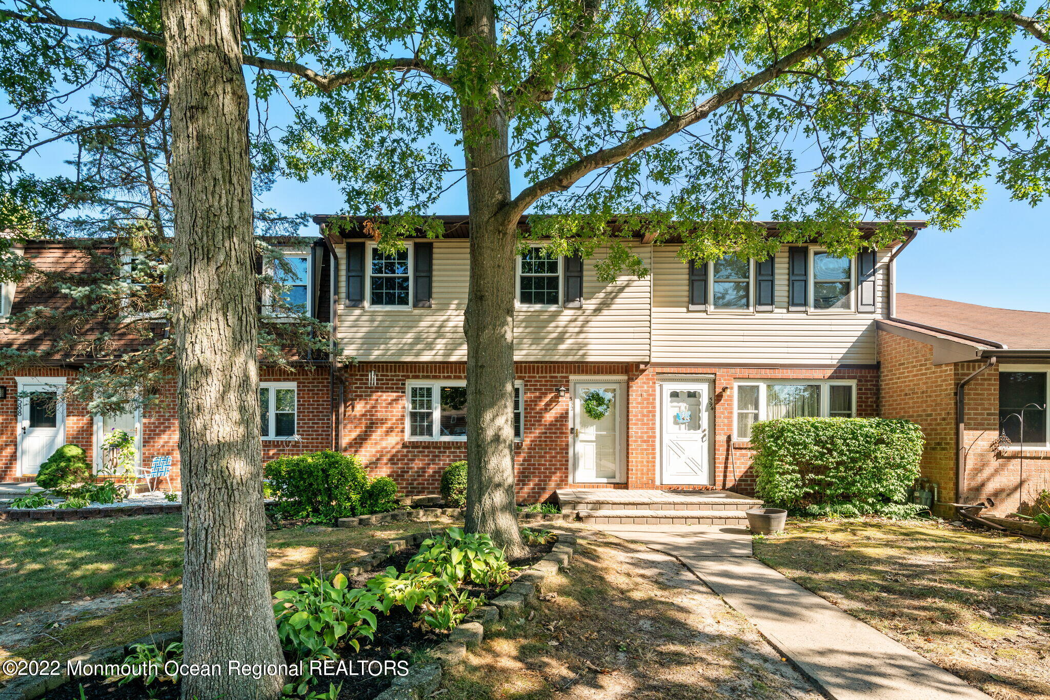 front view of a house with a tree in front of it