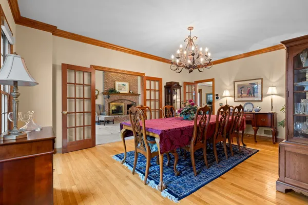 a view of a dining room with furniture a chandelier and wooden floor