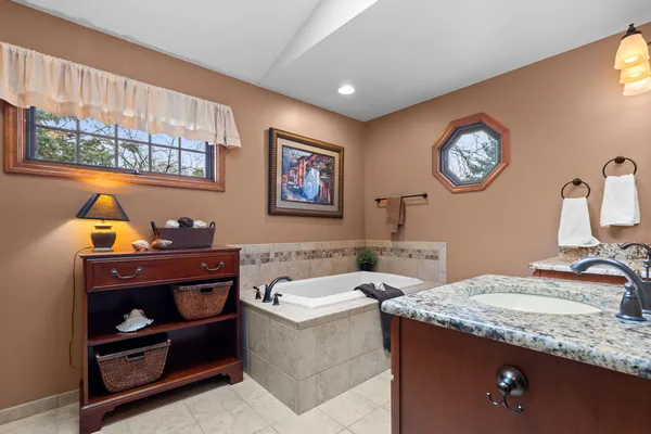 a bathroom with a granite countertop sink and a mirror