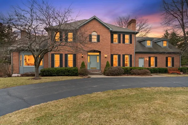 a front view of a house with yard and trees