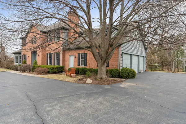 a view of a house with a yard and large tree