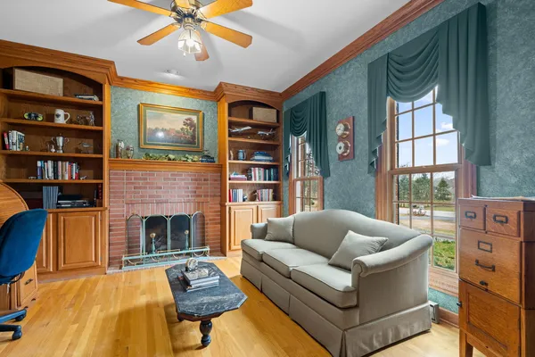 a living room with furniture fireplace and a large window