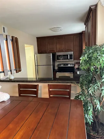 a open kitchen with wooden cabinets and a stove