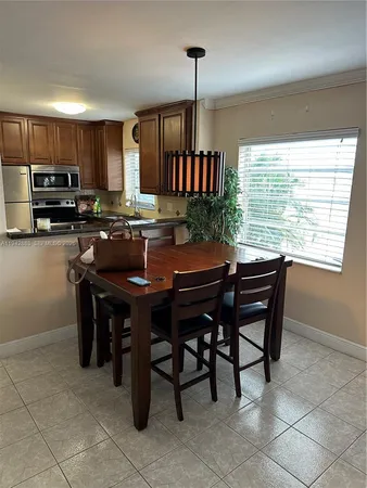 a kitchen with a kitchen island a stove a table and chairs in it
