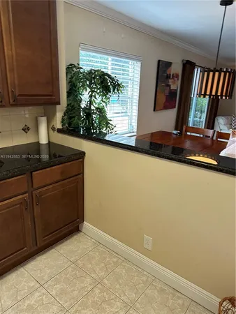 a kitchen with granite countertop white cabinets and window