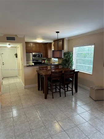 a view of a kitchen with kitchen island granite countertop a table and chairs in it
