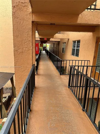 a view of staircase with lots of frames on wall and a window