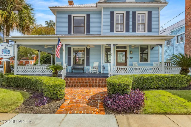 a living room with couches chairs and a dining table with wooden floor