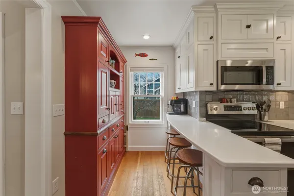 a kitchen with granite countertop a stove a sink and a microwave