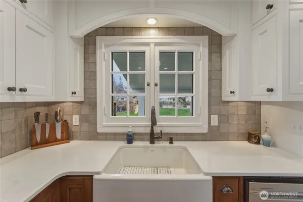 a kitchen with a sink a center island a stove cabinets and wooden floor