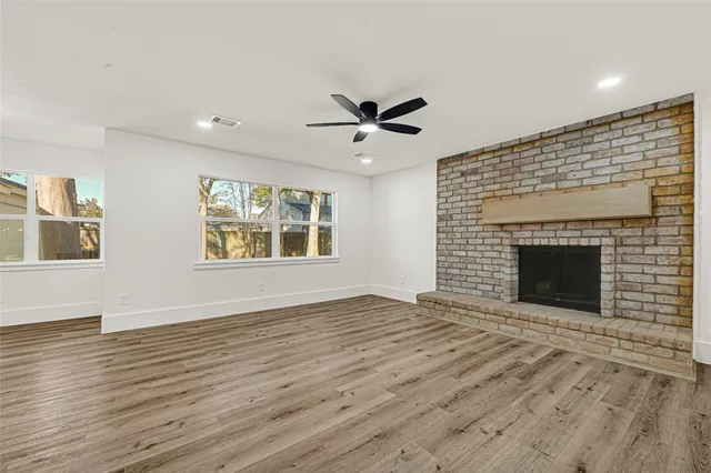 a view of an empty room with a fireplace and a window
