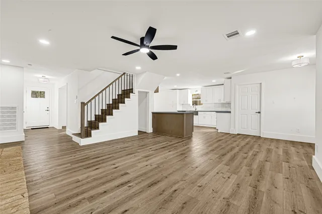 a view of empty room with wooden floor and windows