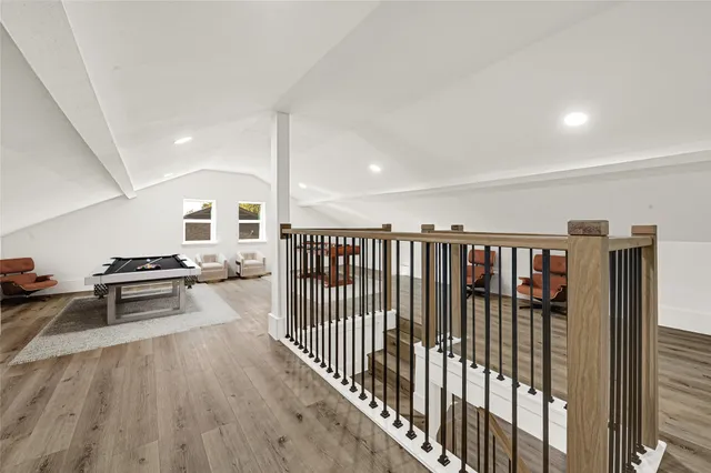 a view of a hallway with wooden floor and windows