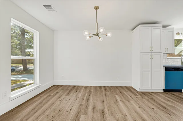 a view of a room with wooden floor and white walls