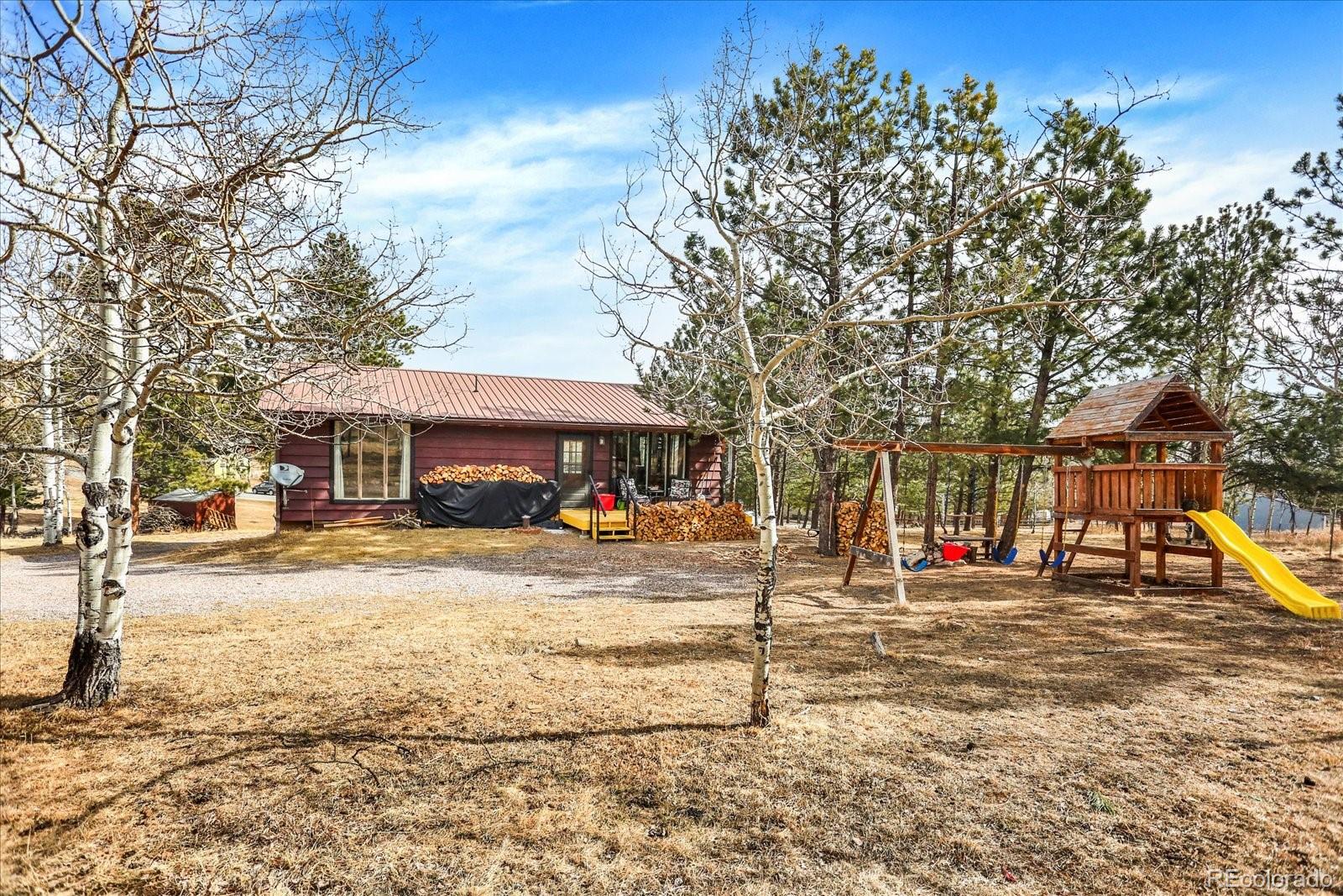 249 Burland Drive Bailey, CO 80421 - Photo 1 of 34 a front view of residential houses with yard and trees