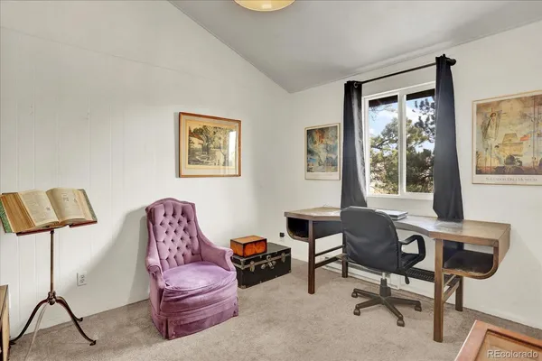 a livingroom with workspace couch and a window