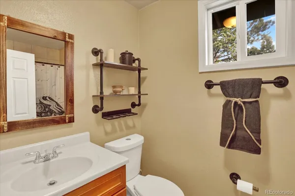 a bathroom with a sink toilet and mirror