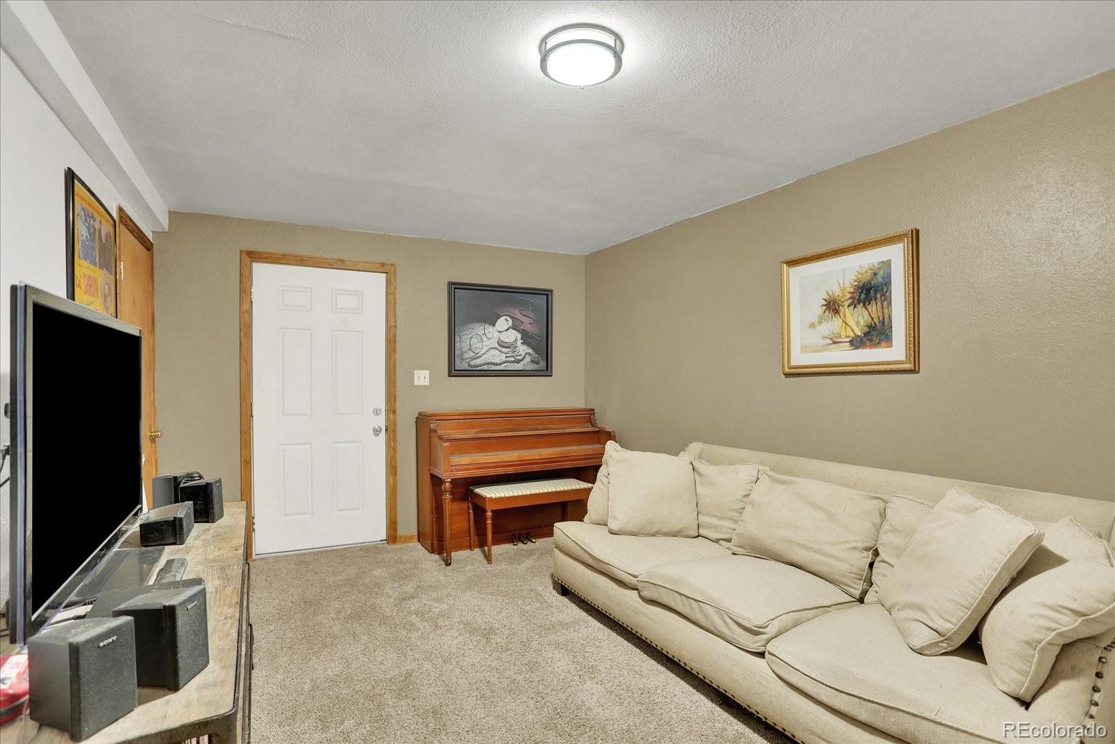 249 Burland Drive Bailey, CO 80421 - Photo 19 of 34 a living room with furniture and a flat screen tv