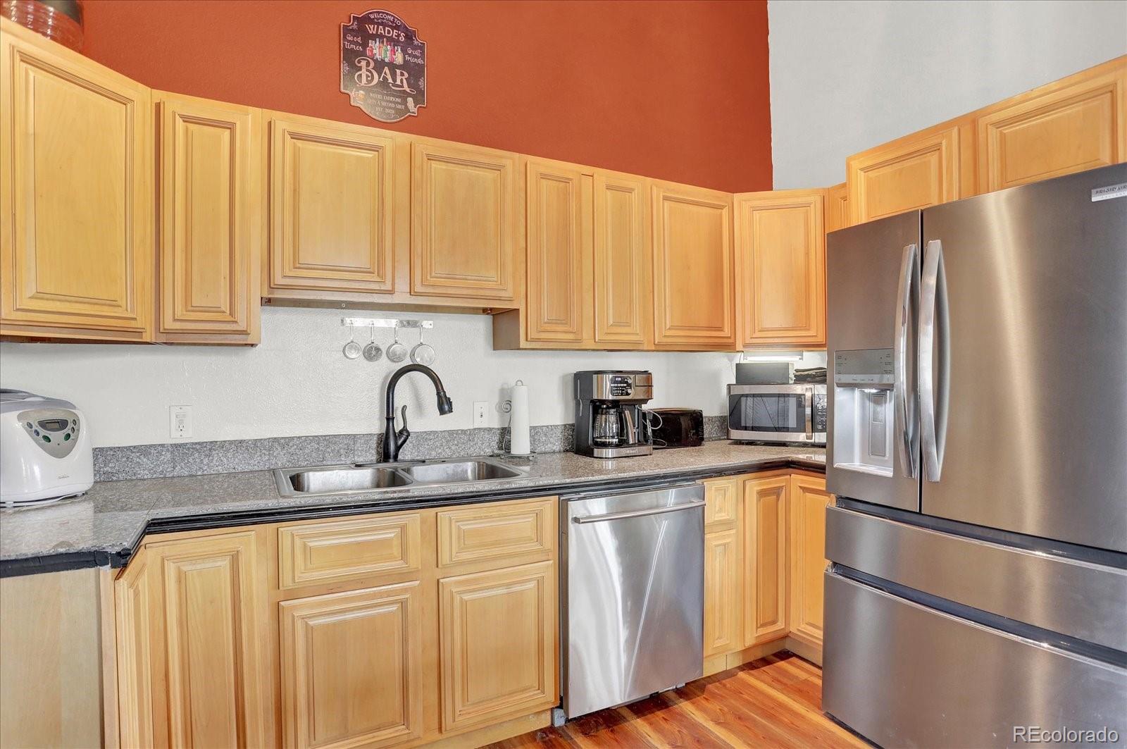 249 Burland Drive Bailey, CO 80421 - Photo 7 of 34 a kitchen with stainless steel appliances granite countertop a refrigerator sink and white cabinets
