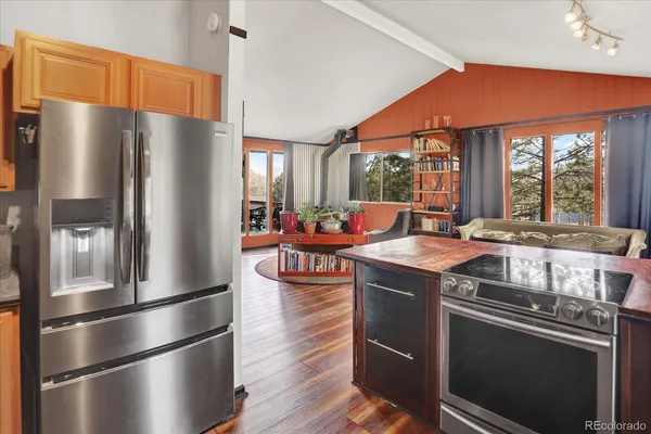 a kitchen with stainless steel appliances a refrigerator a sink a stove and a refrigerator