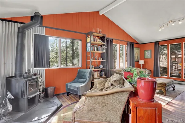 a living room with furniture a fireplace and large windows