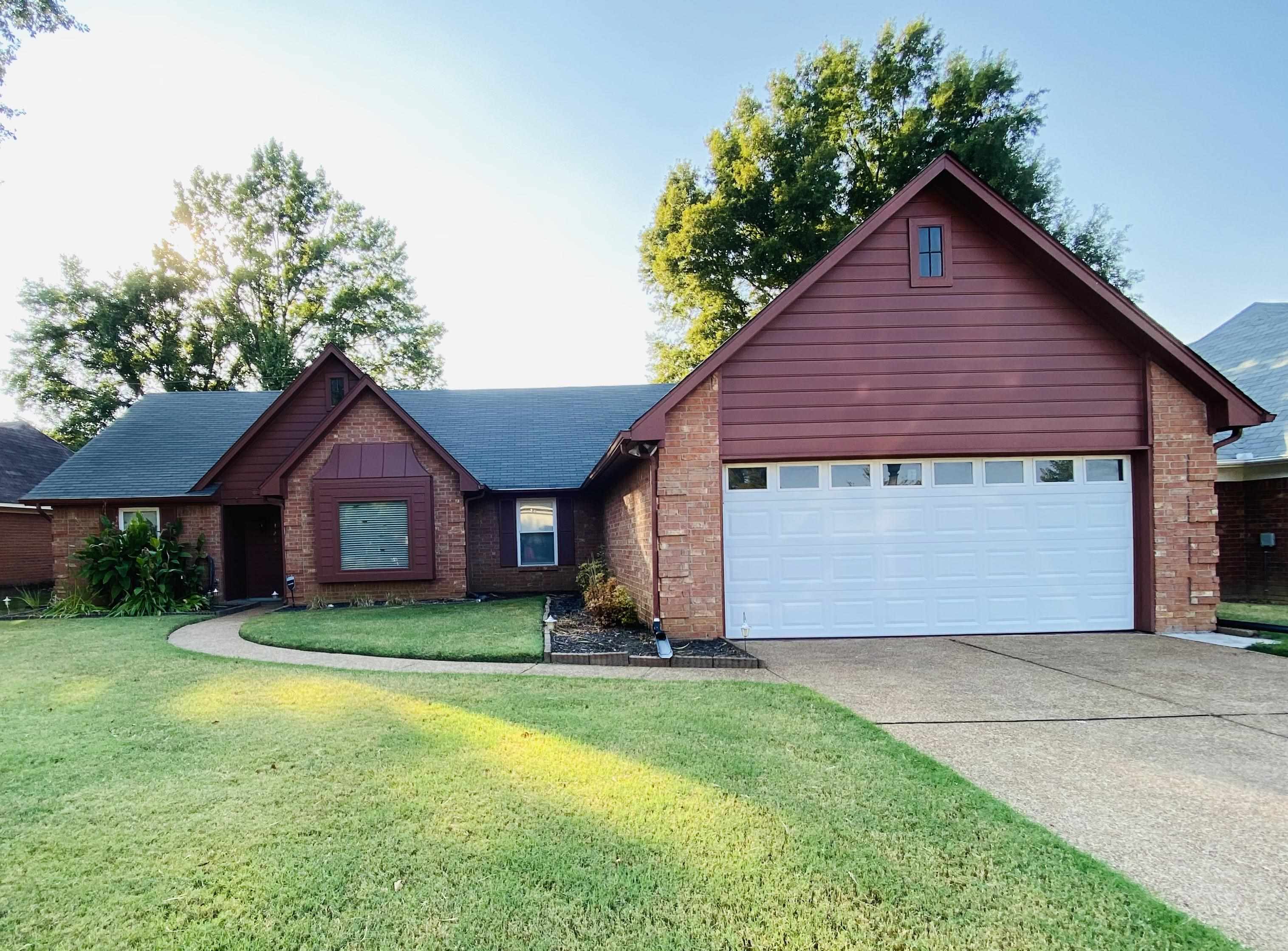 1235 Creeks Edge Cove Memphis, TN 38016 - Photo 1 of 15 Ranch-style home featuring brick siding, concrete driveway, a front yard, and an attached garage
