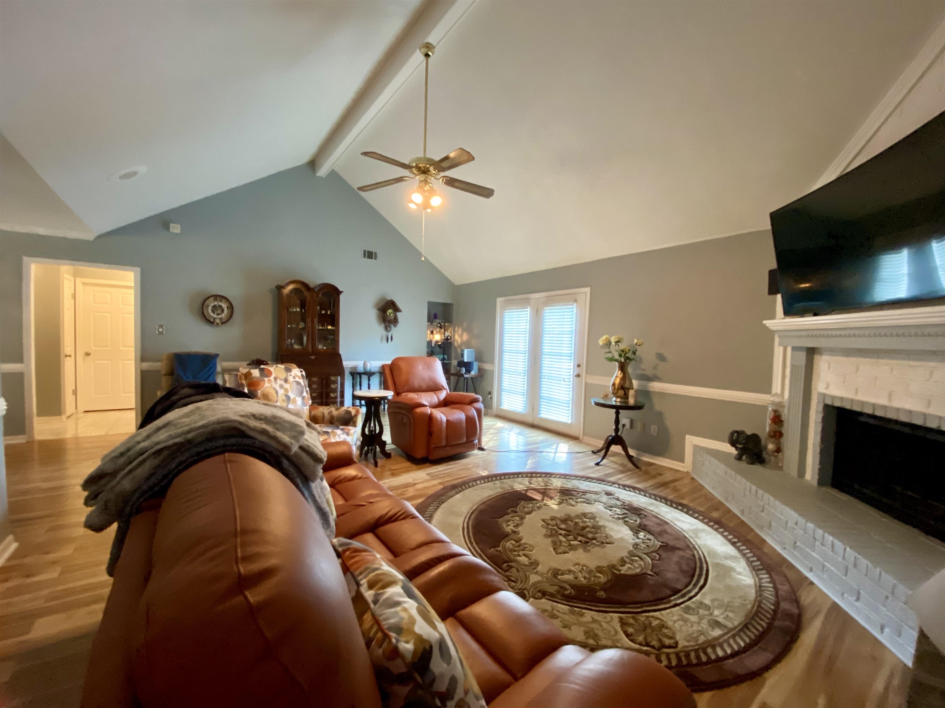 1235 Creeks Edge Cove Memphis, TN 38016 - Photo 11 of 15 Living area featuring beamed ceiling, light wood-style floors, high vaulted ceiling, a fireplace, and ceiling fan