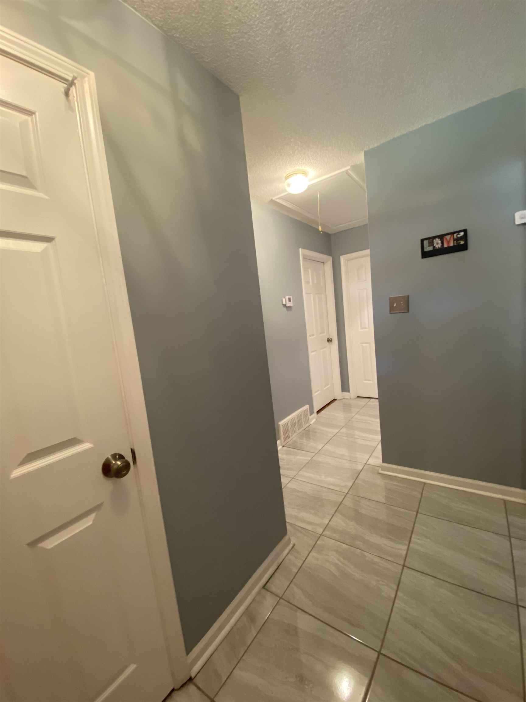 1235 Creeks Edge Cove Memphis, TN 38016 - Photo 2 of 15 Front Entrance Hall featuring a textured ceiling, light tile patterned flooring, and attic access