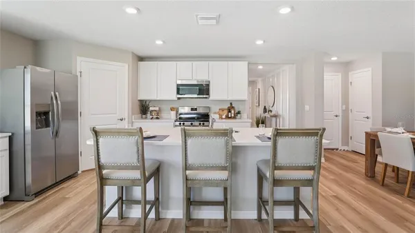 a kitchen with kitchen island white cabinets and stainless steel appliances
