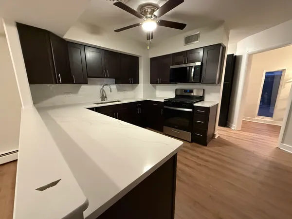 a kitchen with stainless steel appliances a microwave a stove and white cabinets