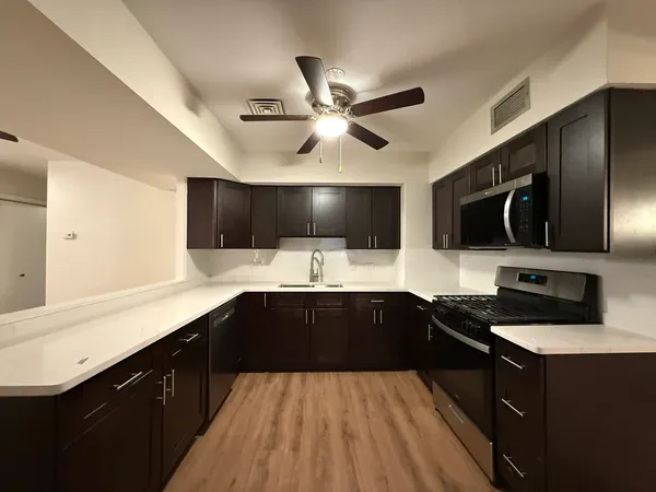 a kitchen with stainless steel appliances kitchen island granite countertop a stove and a refrigerator