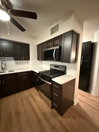 a kitchen with kitchen island a counter top space appliances and cabinets