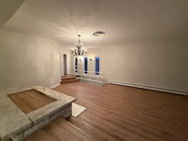 an empty room with wooden floor and staircase