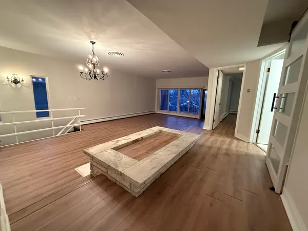 a view of a room with wooden floor and chandelier