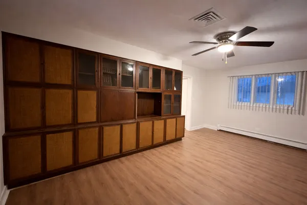 a view of an empty room with wooden floor