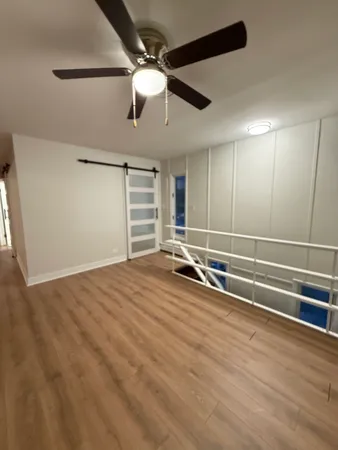 a view of a room with gym equipment and a ceiling fan