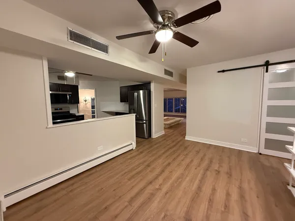 a view of a kitchen with wooden floor and a ceiling fan