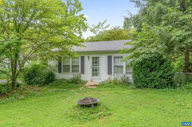 an aerial view of residential houses with outdoor space and trees