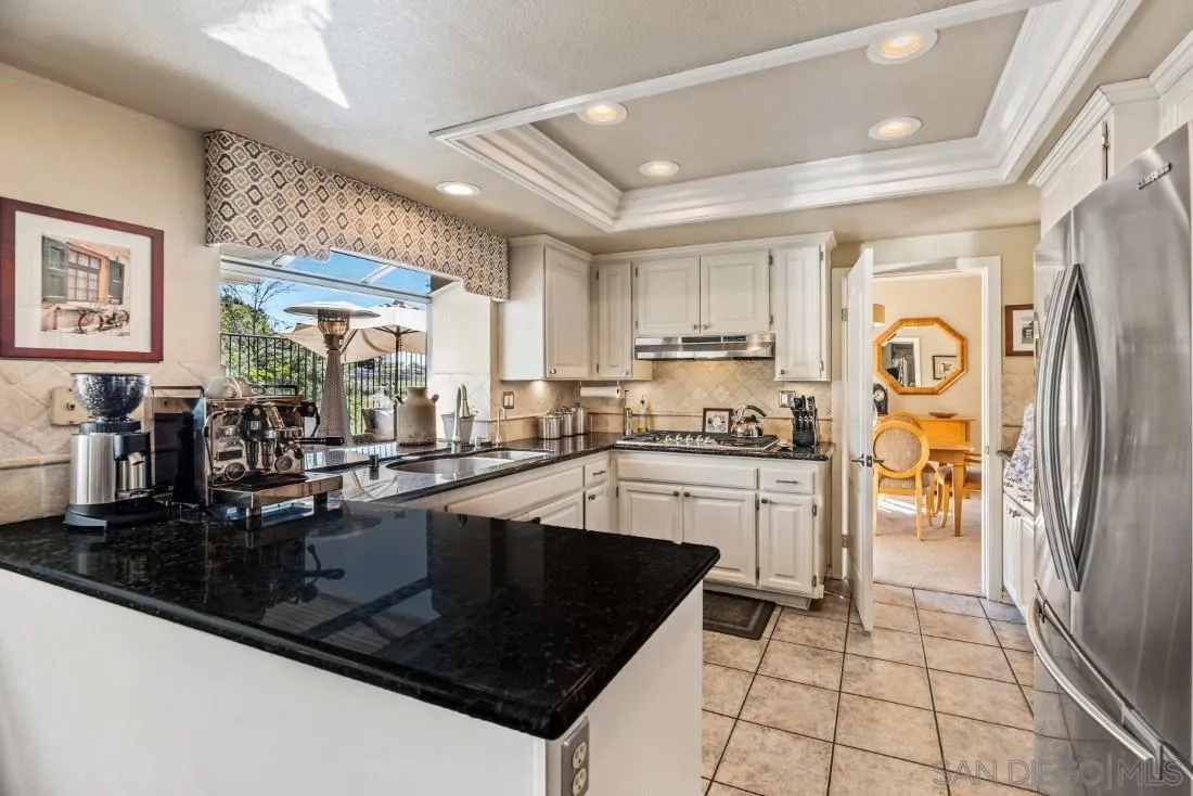 13755 Royal Melbourne Square San Diego, CA 92128 - Photo 13 of 75 a kitchen with stainless steel appliances granite countertop a refrigerator a sink dishwasher a stove and white countertops with wooden floor