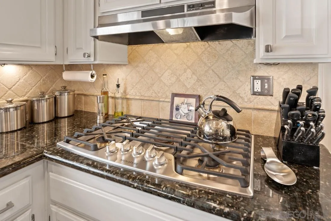 13755 Royal Melbourne Square San Diego, CA 92128 - Photo 16 of 75 a kitchen with a stove and cabinets